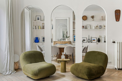 Cette image montre un grand salon blanc et bois design ouvert et haussmannien avec une salle de réception, un mur blanc, parquet clair, une cheminée standard et un manteau de cheminée en pierre.