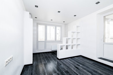 На фото: хозяйская спальня среднего размера в современном стиле с белыми стенами, полом из ламината и черным полом с