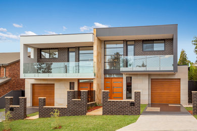 Ejemplo de fachada de casa bifamiliar multicolor y negra moderna de tamaño medio de dos plantas con revestimiento de piedra, tejado plano y tejado de metal