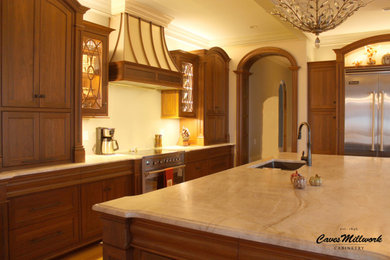 Expansive traditional kitchen in New York with an undermount sink, beaded inset cabinets, brown cabinets, quartzite benchtops, stainless steel appliances, light hardwood floors, with island, beige floor and beige benchtop.