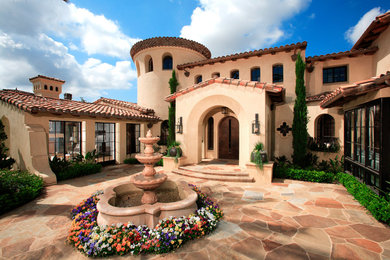 Example of a tuscan beige exterior home design in Orange County