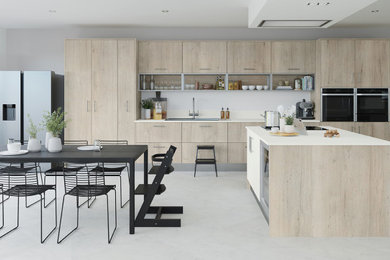Foto de cocina grande abierta con fregadero encastrado, puertas de armario de madera clara, salpicadero blanco, electrodomésticos negros, una isla, suelo gris y encimeras blancas