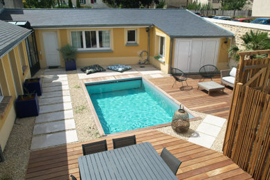 Cette image montre un petit piscine avec aménagement paysager méditerranéen rectangle avec une cour et une terrasse en bois.