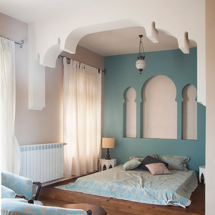 Immagine di una camera degli ospiti etnica di medie dimensioni con pareti blu e parquet chiaro