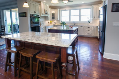 Elegant u-shaped kitchen photo in Other with raised-panel cabinets, white cabinets and two islands