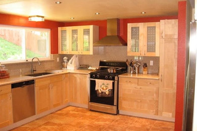 Example of a mid-sized transitional l-shaped ceramic tile and brown floor enclosed kitchen design in San Francisco with an undermount sink, recessed-panel cabinets, light wood cabinets, quartz countertops, beige backsplash, stone slab backsplash, stainless steel appliances and no island