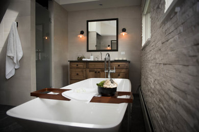 Inspiration for a large modern master bathroom in Other with shaker cabinets, medium wood cabinets, a freestanding tub, a corner shower, a one-piece toilet, white tile, stone tile, white walls, slate floors, a drop-in sink, solid surface benchtops, black floor, a hinged shower door and grey benchtops.
