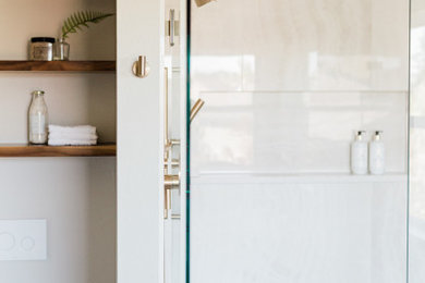Example of a large transitional master white tile and porcelain tile porcelain tile, gray floor and double-sink bathroom design in Phoenix with flat-panel cabinets, medium tone wood cabinets, a bidet, gray walls, an undermount sink, quartz countertops, a hinged shower door, white countertops and a floating vanity