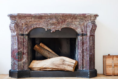 Example of a classic dining room design in DC Metro with a standard fireplace and a stone fireplace