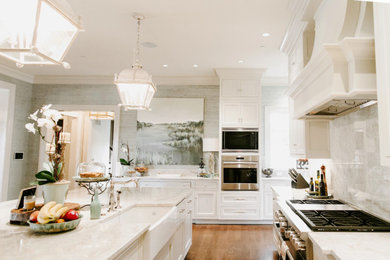 Inspiration for a large timeless u-shaped medium tone wood floor and brown floor open concept kitchen remodel in Baltimore with a farmhouse sink, shaker cabinets, white cabinets, white backsplash, marble backsplash, paneled appliances, an island and white countertops