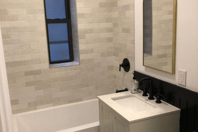 Example of a classic master gray tile and porcelain tile marble floor, white floor, single-sink and wainscoting bathroom design in New York with white cabinets, marble countertops, white countertops, shaker cabinets, a one-piece toilet, white walls, a drop-in sink and a freestanding vanity