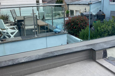 Imagen de balcones moderno de tamaño medio sin cubierta con privacidad y barandilla de vidrio