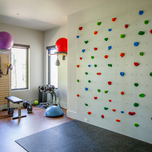 Inspiration for a contemporary home gym in Jacksonville with white walls and brown floors.
