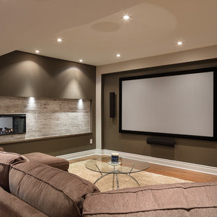 Inspiration for a large contemporary fully buried basement in Ottawa with beige walls, laminate floors, a two-sided fireplace, a tiled fireplace surround and brown floors.