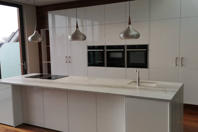 Medium sized modern single-wall open plan kitchen in Other with quartz worktops and an island.