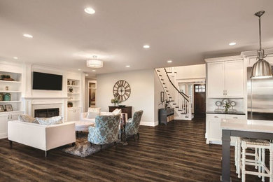 Inspiration for a mid-sized transitional open concept family room in Sacramento with grey walls, dark hardwood floors, a standard fireplace, a wall-mounted tv and brown floor.