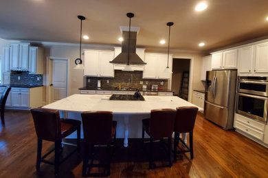 Inspiration for a large timeless kitchen remodel in Atlanta with flat-panel cabinets, stainless steel appliances and an island