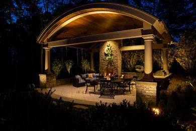 Mid-sized elegant backyard stone patio kitchen photo in Other with a gazebo