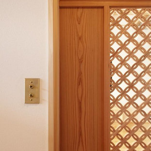 Idee per un piccolo corridoio etnico con pareti bianche, pavimento in legno massello medio, una porta scorrevole, una porta in legno bruno, pavimento arancione e soffitto in legno