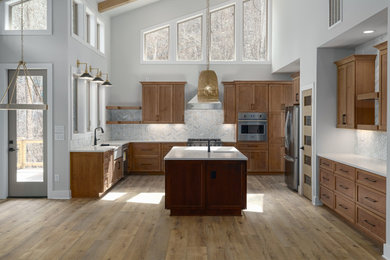 Foto di una grande cucina moderna con lavello stile country, ante in stile shaker, ante in legno scuro, top in quarzo composito, paraspruzzi bianco, paraspruzzi con piastrelle di vetro, elettrodomestici in acciaio inossidabile, pavimento in vinile, pavimento marrone, top bianco e travi a vista