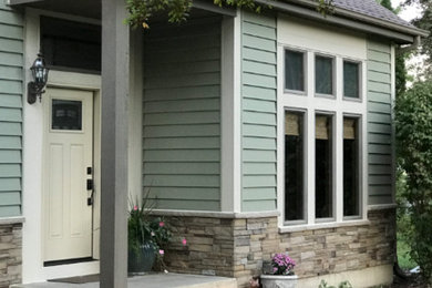 Photo of a large traditional green house exterior in Chicago with vinyl siding.