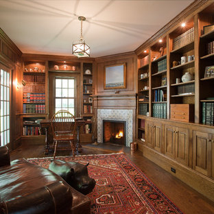 This is an example of a large traditional study room in New York with brown walls, dark hardwood floors, a corner fireplace, a tile fireplace surround and a freestanding desk.