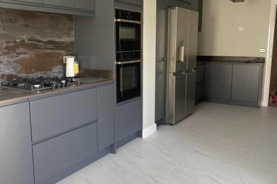 Medium sized modern single-wall enclosed kitchen in Other with laminate floors, no island and white floors.