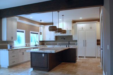 Mid-sized elegant l-shaped travertine floor and beige floor kitchen photo in Other with white cabinets, an island, an undermount sink, raised-panel cabinets, granite countertops, beige backsplash, porcelain backsplash and paneled appliances