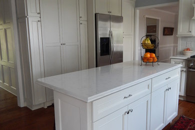 Mid-sized elegant l-shaped dark wood floor eat-in kitchen photo in Other with a double-bowl sink, beaded inset cabinets, white cabinets, quartz countertops, white backsplash, ceramic backsplash, stainless steel appliances and an island