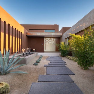 Idee per una porta d'ingresso design di medie dimensioni con pareti rosa, pavimento in cemento, una porta a pivot, una porta bianca e pavimento grigio