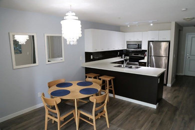 Photo of a small contemporary kitchen/dining combo in Vancouver with grey walls, laminate floors and grey floor.