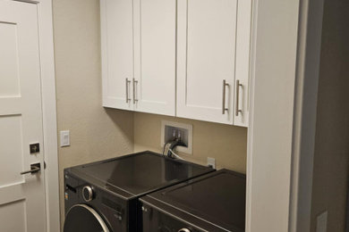 Inspiration for a contemporary medium tone wood floor and brown floor laundry room remodel in Phoenix with beige walls and a side-by-side washer/dryer