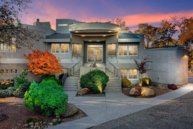 This is an example of a large contemporary three-storey grey house exterior in Sacramento with a flat roof and a mixed roof.