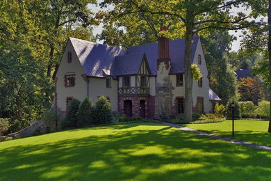 Large elegant beige two-story stucco house exterior photo in DC Metro with a shingle roof