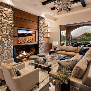 Offenes Mediterranes Wohnzimmer mit weißer Wandfarbe, braunem Holzboden, Gaskamin und Wand-TV in Phoenix