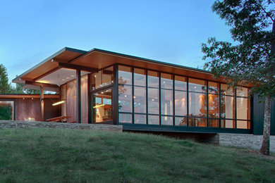 Modern brown mixed siding house exterior idea in Charlotte with a shed roof