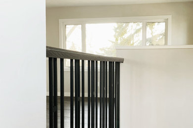 Inspiration for a small contemporary carpeted straight wood railing staircase remodel in Calgary with carpeted risers