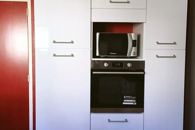 Foto de cocina lineal clásica de tamaño medio con puertas de armario blancas, electrodomésticos con paneles y suelo marrón