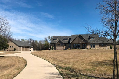 Large transitional beige two-story brick exterior home photo in Dallas with a shingle roof