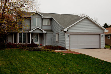 Large transitional two-storey grey house exterior in Detroit with vinyl siding, a gable roof and a tile roof.