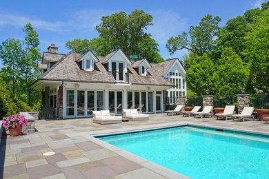 Foto de casa de la piscina y piscina a medida en patio trasero con adoquines de piedra natural