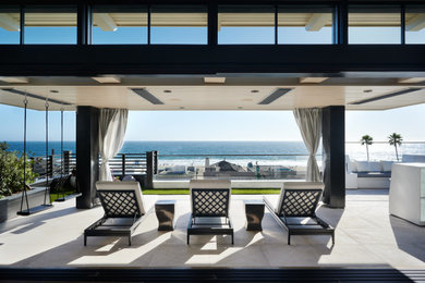 Inspiration for a large mediterranean glass railing balcony remodel in Los Angeles with a fireplace and a roof extension