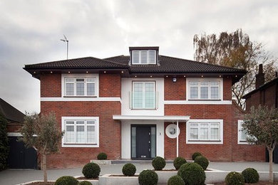 This is an example of a large and red contemporary brick detached house in Cornwall with three floors, a pitched roof and a tiled roof.