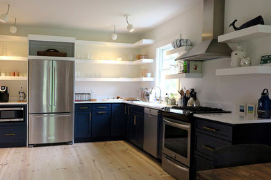 Small trendy l-shaped light wood floor and beige floor eat-in kitchen photo in Boston with an undermount sink, shaker cabinets, blue cabinets, quartz countertops, white backsplash, stainless steel appliances and no island