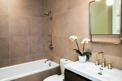 Inspiration for a contemporary beige tile and porcelain tile porcelain tile bathroom remodel in San Francisco with an integrated sink, flat-panel cabinets, dark wood cabinets, a two-piece toilet and quartz countertops