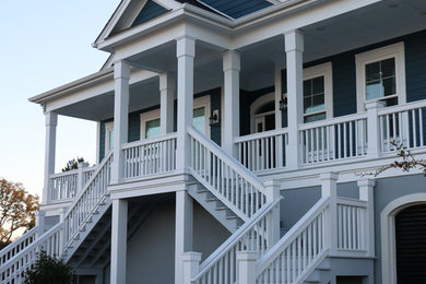 Mid-sized beach style blue two-story concrete fiberboard house exterior photo in Other with a hip roof and a shingle roof