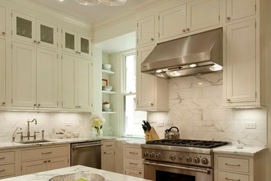 This is an example of a traditional kitchen in New York with an undermount sink, recessed-panel cabinets, white cabinets, marble benchtops, stainless steel appliances, white splashback, medium hardwood floors and with island.