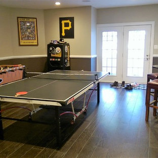 This is an example of a large classic fully buried basement in Baltimore with multi-coloured walls, medium hardwood flooring and beige floors.