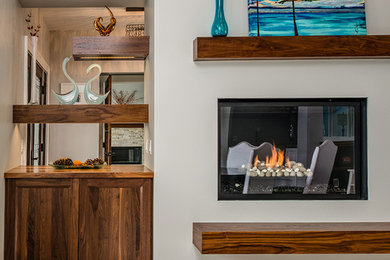 Example of a large trendy open concept dark wood floor family room design in Other with a standard fireplace, a wood fireplace surround, a media wall and gray walls