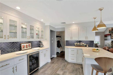 Kitchen - large modern porcelain tile and gray floor kitchen idea in New York with a farmhouse sink, glass-front cabinets, white cabinets, black backsplash, porcelain backsplash and stainless steel appliances